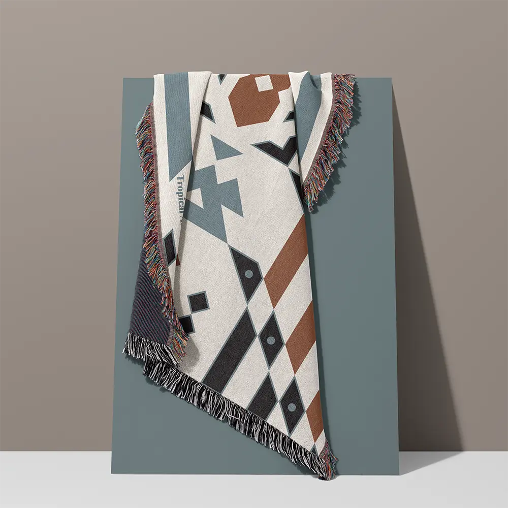 Wandering Warrior Blanket with blue and brown patterns draped over a grey board, showcasing the full design and decorative tassels.