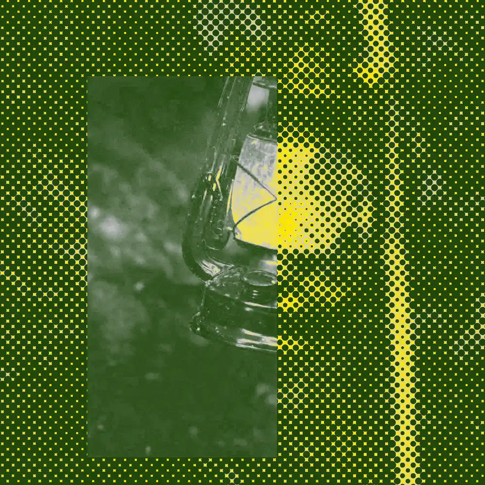 A retro Pop Art style image of a vintage kerosene oil lantern, rendered in a bold deep forest green and neon yellow color palette. The image features a strong halftone dot pattern over an abstract, blurry outdoor background, creating a high-contrast screen-printed aesthetic that evokes a nomadic, industrial vibe.