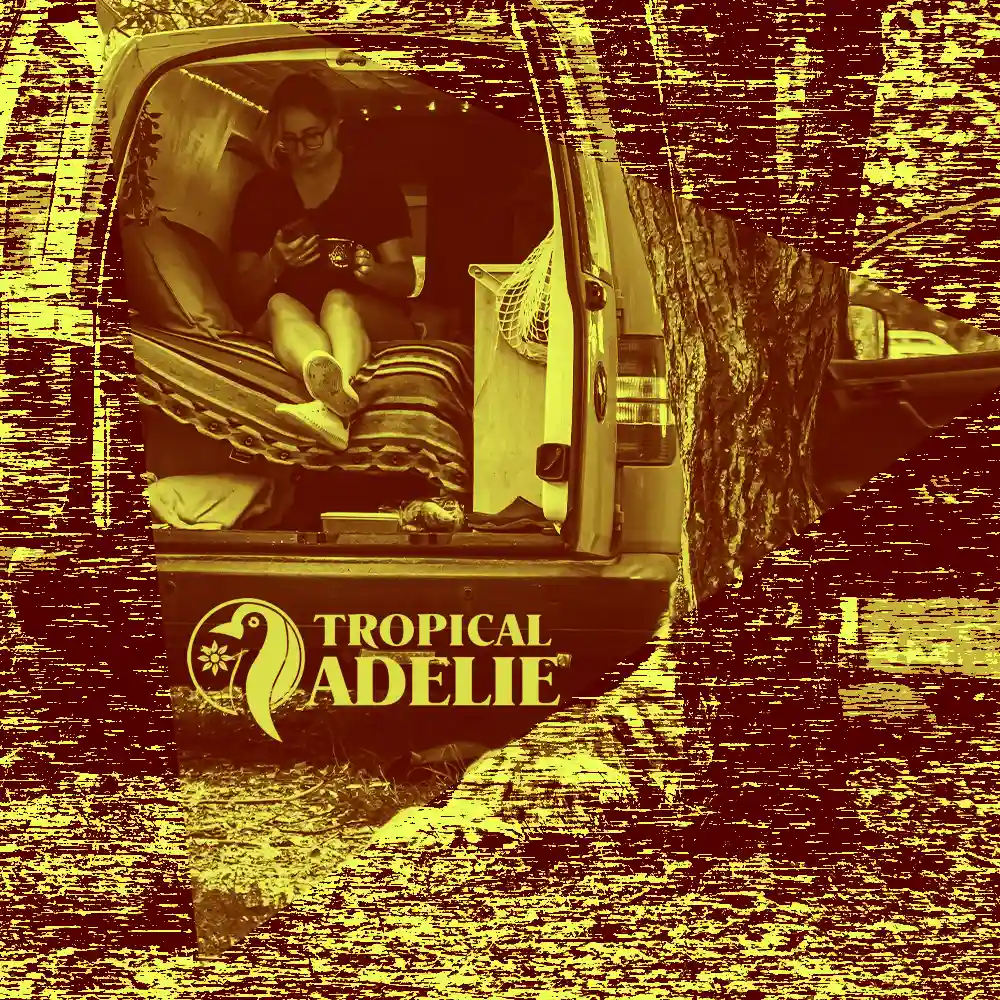 A yellowish photo of a girl is playing cellphone with a mug of drink on the other hand. With the logo of Tropical Adelie.