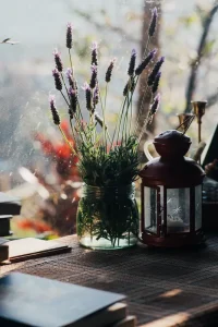Lavender in a glass jar beside a rustic lantern on a windowsill — a simple way to make your room more cozy with nature-inspired decor
